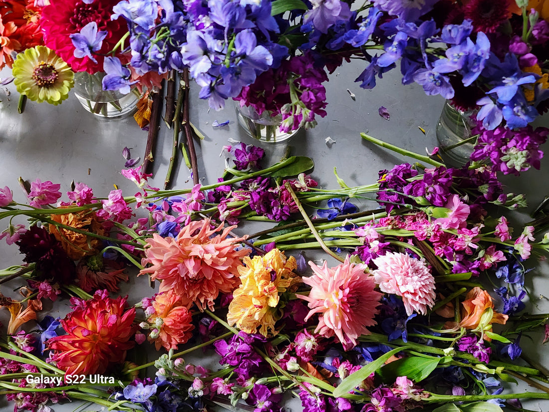 workbench with bright colored cut flower stems  laying on the workbench. 